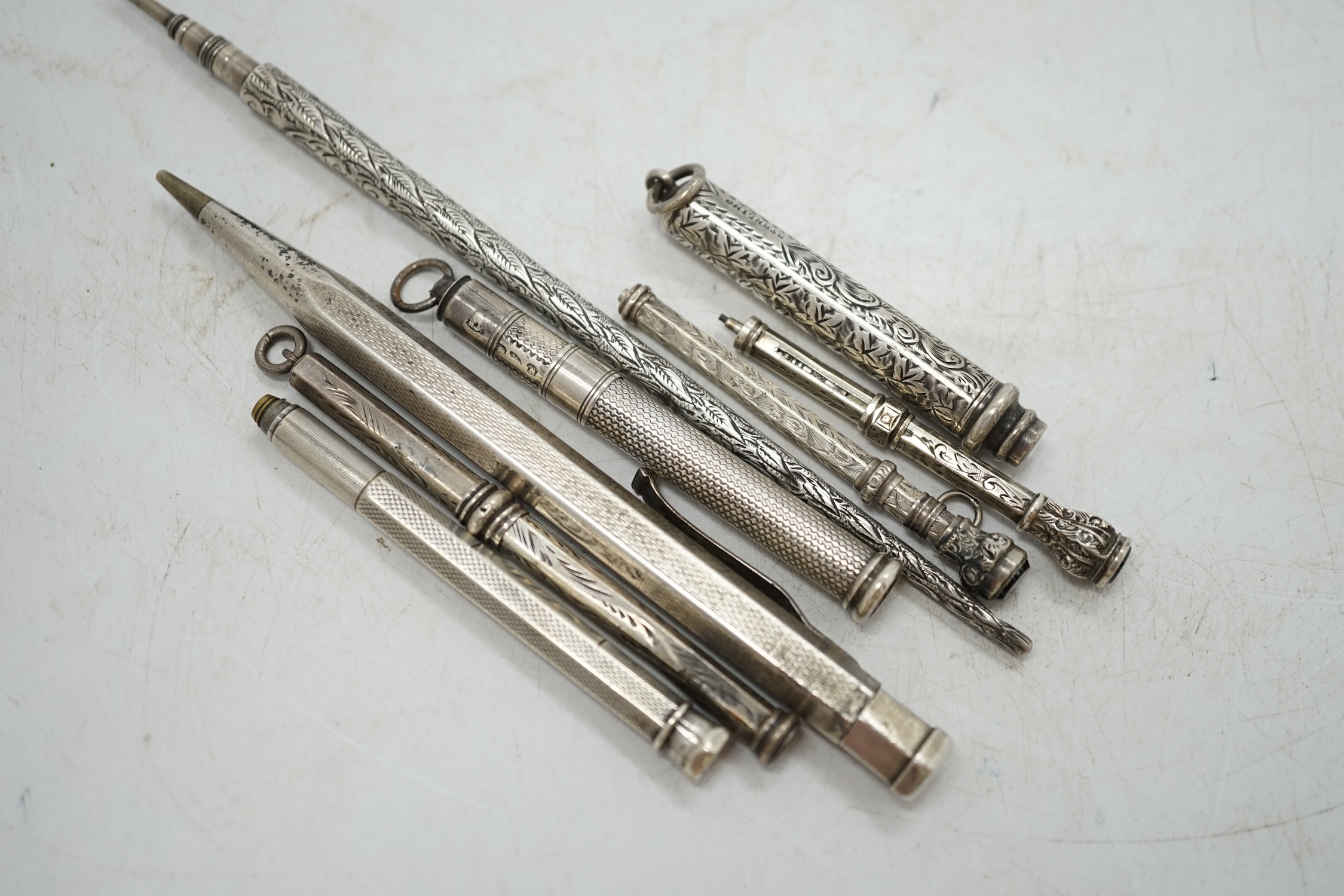 An engine turned silver cased Yard-O-Led pencil, three silver cased propelling pencils, a sterling cased propelling pencil and three white metal cased pencils. Condition - fair